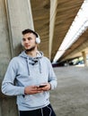 Man runner taking a break after intensive training outdoors, listening music on his mobile smart phone Royalty Free Stock Photo