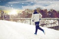 Man running along snow covered winter bridge road