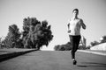 Man running on asphalt road on sunny summer day Royalty Free Stock Photo