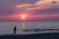 Man running on the beach while the sun is setting