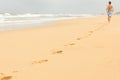 Man running on empty wild beach leaving his footprints on the sand Royalty Free Stock Photo