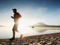 Man running at seaside twilight time. Runner athlete running at seaside. Sportsman fitness silhouette Royalty Free Stock Photo