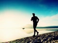 Man running at seaside twilight time. Runner athlete running at seaside. Sportsman fitness silhouette Royalty Free Stock Photo