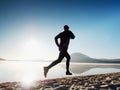 Man running at seaside twilight time. Runner athlete running at seaside. Sportsman fitness silhouette Royalty Free Stock Photo