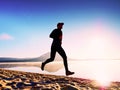 Man running at seaside twilight time. Runner athlete running at seaside. Sportsman fitness silhouette Royalty Free Stock Photo