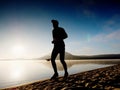 Man running at seaside twilight time. Runner athlete running at seaside. Sportsman fitness silhouette Royalty Free Stock Photo