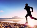 Man running at seaside twilight time. Runner athlete running at seaside. Sportsman fitness silhouette Royalty Free Stock Photo