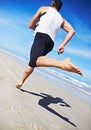 Man, running and water at beach with fitness, sport and training for marathon by the sea. Workout, exercise and back of Royalty Free Stock Photo