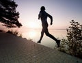 Man runs on pavement in lake bay. Regular morning training