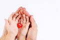 Man's and baby's hands holding a red heart