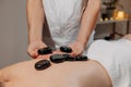 Man`s back during massage with hot stones. Body care and SPA in resort Royalty Free Stock Photo