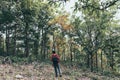 Man 20-30s of backpacker standing and looking forward, walking alone in deep autumn forest. traveling, active lifestyle adventure Royalty Free Stock Photo