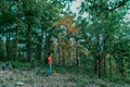 Man 20-30s of backpacker standing and looking forward, walking alone in deep autumn forest. traveling, active lifestyle adventure Royalty Free Stock Photo