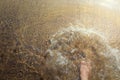 Man`s barefoot jumps into the glassy puddle on the empty road after hard rainfall. Crystal clear water splashes with the high-spee Royalty Free Stock Photo