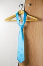 A man`s blue tie hangs on the door of the chiffonier. The concept of a successful man`s style