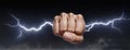 A man\'s clenched fist holding lightning striking. Royalty Free Stock Photo