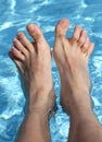Man's feet on the bathtub of a relaxing pool