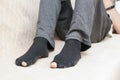 A man's feet in old black socks with holes in the big toe Royalty Free Stock Photo