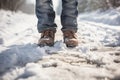 A man& x27;s feet in winter shoes take a step on a snowy road on a winter walk. Generative AI