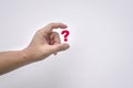 Man`s fingers virtually hold a red question mark on white background Royalty Free Stock Photo