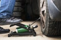 Man`s foot pumping up a flat car tyre or tire, which is deflated. Man Inflating car tyre with foot pump. Concept of checking a ca Royalty Free Stock Photo
