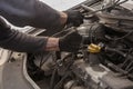 Man`s gloved hand repairs a car engine