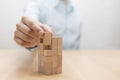 Man`s hand adding the last missing wooden block into place. Royalty Free Stock Photo