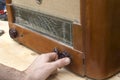 Man`s hand adjusts the potentiometer scale in the old vintage radio tube.
