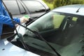 Man`s hand applies liquid to clean the windshield of the car window. Royalty Free Stock Photo