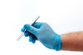 Man`s hand in blue latex glove holding stainless medical tweezers isolated on white background Royalty Free Stock Photo