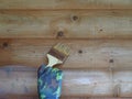 A man`s hand with a brush to paint a wooden wall. Royalty Free Stock Photo