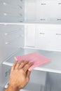 Man`s hand cleaning fridge. Regular cleaning home refrigerator inside Royalty Free Stock Photo