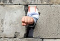 The man`s hand squeezed into a fist smashes through the wall of gray concrete blocks. Symbol of struggle, victory and liberation Royalty Free Stock Photo