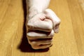 Man`s hand clenched into a fist on the table