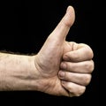 Man`s hand clenched into a fist with thumb up on the black background like gesture Royalty Free Stock Photo