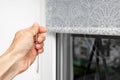a man& x27;s hand closes fabric blinds, close-up Royalty Free Stock Photo