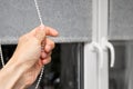 a man& x27;s hand closes fabric blinds, close-up. Royalty Free Stock Photo