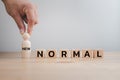 Man`s hand with concept of new normal, wooden block cubes for new normal wording The world is changing to balance it into new nor Royalty Free Stock Photo