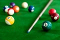 Man`s hand and Cue arm playing snooker game or preparing aiming to shoot pool balls on a green billiard table Royalty Free Stock Photo