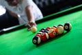 Man`s hand and Cue arm playing snooker game or preparing aiming to shoot pool balls on a green billiard table Royalty Free Stock Photo