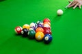 Man`s hand and Cue arm playing snooker game or preparing aiming to shoot pool balls on a green billiard table Royalty Free Stock Photo