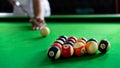 Man`s hand and Cue arm playing snooker game or preparing aiming to shoot pool balls on a green billiard table Royalty Free Stock Photo