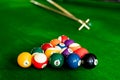 Man`s hand and Cue arm playing snooker game or preparing aiming to shoot pool balls on a green billiard table