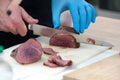 A man`s hand cuts cooked meat