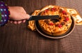 Man`s hand cutting a roscon de reyes with a knife