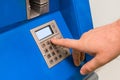 A man`s hand dials a pincode at the terminal for issuing money, close-up Royalty Free Stock Photo