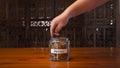 Man`s hand dropping coins in a savings jar to save for pension fund