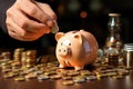 Man\'s hand drops coins into the piggy bank