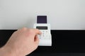 Man's hand entering a PIN code on payment terminal