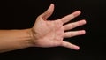 Man\'s hand extended palm facing up against a dark background Royalty Free Stock Photo
